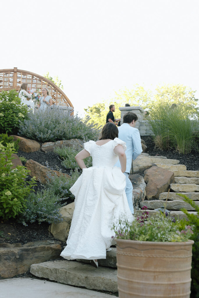 wedding couple walking up steps to their intimate, backyard patio reception